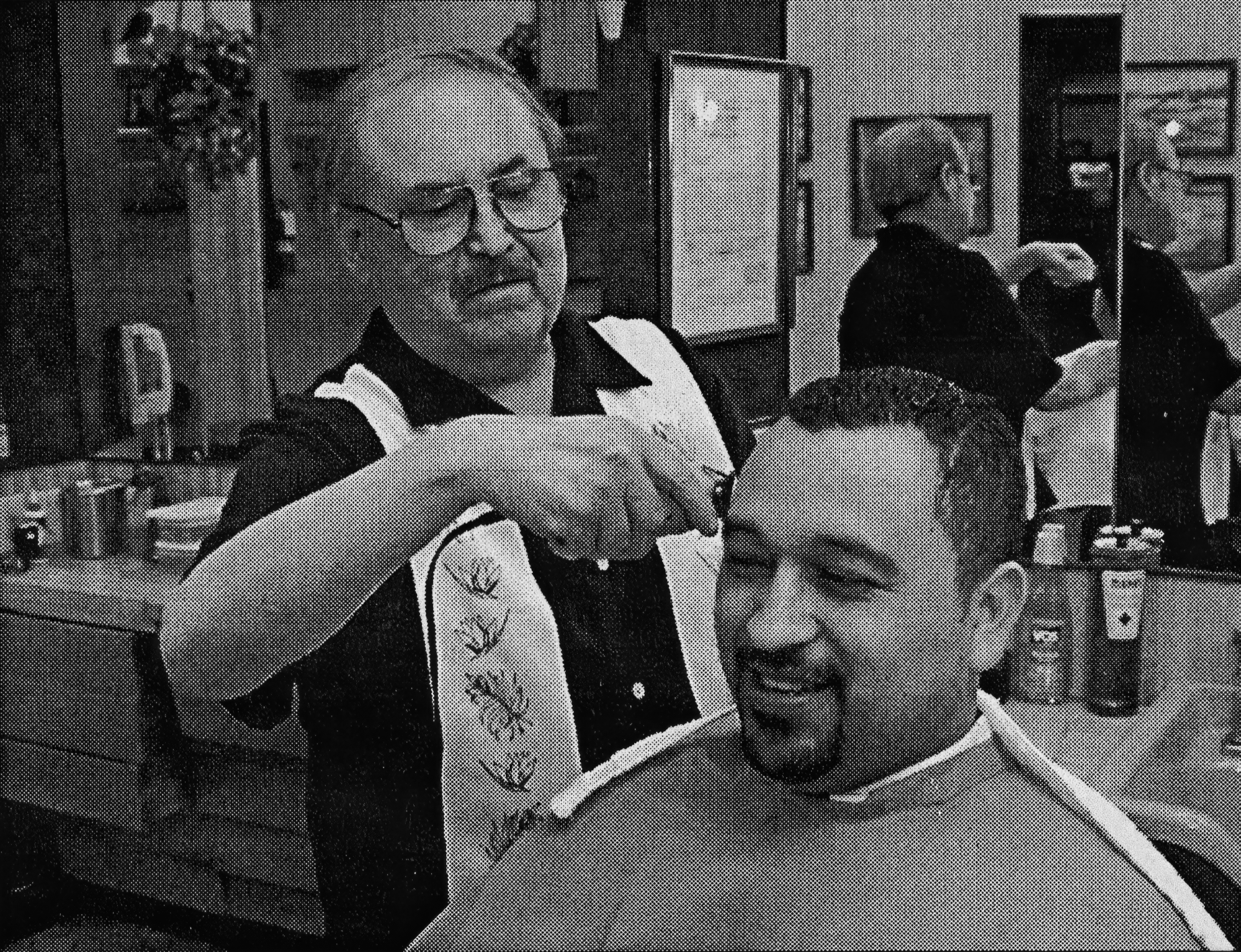 Carlos Rodriguez cutting hair in his Pacific Center barbershop